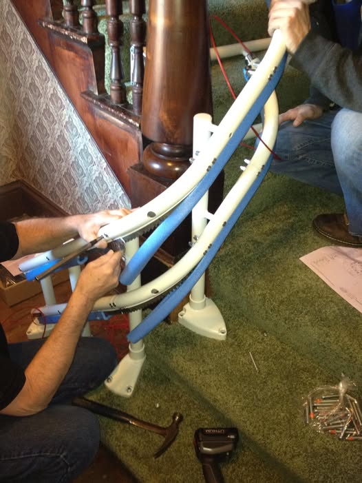 paolo e mario, tecnici partner montascale amico, impegnati nell'installazione del binario di un montascale a poltroncina per scale curve